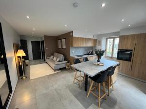 a kitchen and living room with a table and a couch at Appartement Pontarlier-centre in Pontarlier