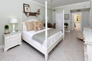 ein Schlafzimmer mit einem weißen Bett mit einem Teddybär darauf in der Unterkunft South Bay Beach Club #11 - 4 Bedroom 4 Bathroom Unit in Dog City