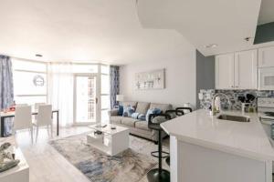a white kitchen and living room with a couch at Stylish Oceanview Getaway Modern 1BR at Carolinian Resort" in Myrtle Beach