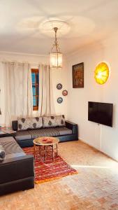 a living room with a couch and a table at apparemment 3 ème étage à-côtés de la plage in Essaouira