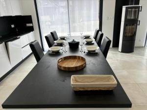 un tavolo nero con sedie e una ciotola di legno in cima di Maison neuve à la montagne a Le Châtelard Altre 11 foto