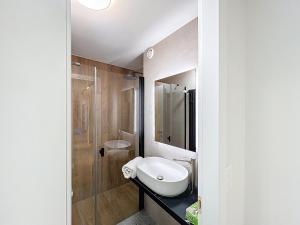 a white bathroom with a sink and a shower at La Duchesse in Crans-Montana +3 photos
