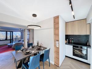 a dining room and kitchen with a table and chairs at La Duchesse in Crans-Montana