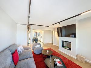 a living room with a couch and a tv at La Duchesse in Crans-Montana