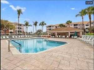 a swimming pool in a resort with chairs and palm trees at 3Bedroom, 2 Bathroom Condo in gated community in Fort Myers
