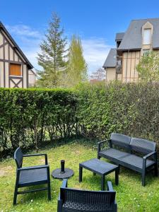 ブロンヴィル・シュル・メールにあるHavre de paixの草の中の椅子とベンチ