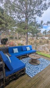 a blue couch and a coffee table on a deck at En bord d'eau - charmant Mobil-home climatisé - Cap ferret in Lège-Cap-Ferret