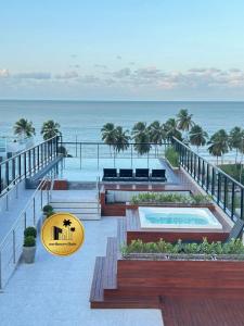 a resort with a swimming pool and the ocean at Melhores Flats - Excepcional, pertinho do mar in João Pessoa