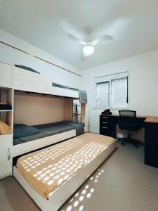 une chambre avec un lit et un bureau avec un ordinateur dans l'établissement Apto Mimoso dos Hóspedes no Centro de Pelotas Novo!, à Pelotas