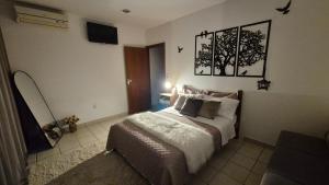 a bedroom with a bed and a tv on the wall at Suite climatizada, ao lado da praca principal in Domingos Martins +10 photos