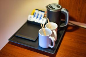 two cups of coffee sitting on a table with a laptop at Clifton House Brighton in Portslade +97 photos