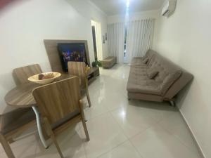 a living room with a couch and a table and chairs at Lindo Apto 404 bem localizado Piratuba SC in Piratuba