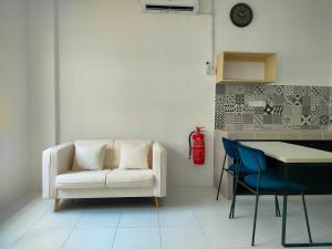a living room with a couch and a table and chairs at IFS SoHo 2 Basic Studio in Seri Iskandar