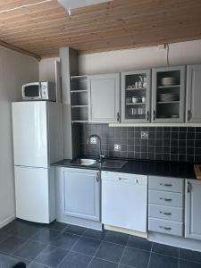 a kitchen with white cabinets and a white refrigerator at Leilighet med 2soverom nær sentrum in Kristiansand
