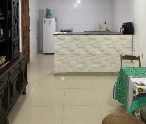 a kitchen with a refrigerator and a tiled floor at Casa Amorim in Lençóis
