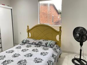 a bedroom with a bed and a fan and a window at Casa Amorim in Lençóis