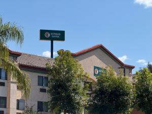 レッドランズにあるCitrus Suites Redlands Loma Linda Hotelの建物の前にあるホテルの看板
