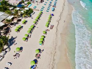 an overhead view of a beach with people and umbrellas at Esmeralda Resort - Orient Bay in Orient Bay