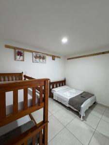 um quarto com uma cama e 2 beliches em Flats Bem Te Vi - Praia Grande em Ubatuba