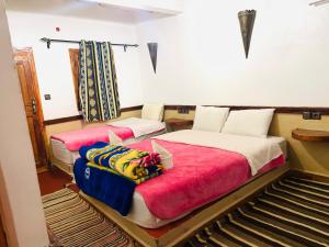A bed or beds in a room at Auberge la belle vue dades