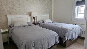 a bedroom with two beds and a window at la casita in Almazán