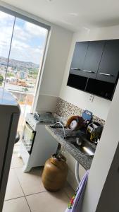 una cucina con bancone e una grande finestra di apartamento em São João del Rei, Brasil vista panoramica a São João del Rei Altre 6 foto