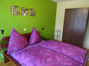 - une chambre avec un lit violet et des oreillers violets dans l'établissement Apartment Schultheiss, à Constance