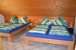 two beds in a room with wooden walls at Ferienwohnung Diana in Rust