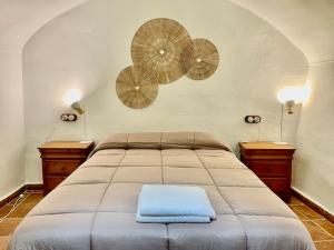 a bedroom with a bed with two tables and two lamps at Casa Cueva Sol con chimenea y piscina privada in Pozo Alcón +33 photos