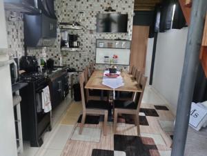 een keuken met een houten tafel met een cake erop bij Chalé Duplex monte fuji ubatumirim in Ubatuba +7 foto's