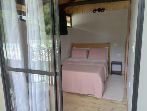 een slaapkamer met een bed met roze lakens en een raam bij Chalé Duplex monte fuji ubatumirim in Ubatuba