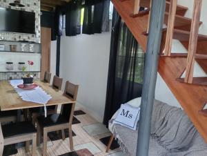 een kamer met een eettafel en een trap bij Chalé Duplex monte fuji ubatumirim in Ubatuba