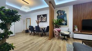 a living room with a table and chairs and a television at Alcatraz Apartment Durres in Durrës