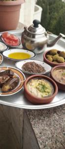 Una mesa llena de diferentes tipos de comida en platos. en Jerash Ruins View -Huge Apartment شقة كبيرة - مطلة على اثار جرش, en Jerash