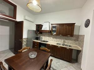 a kitchen with wooden cabinets and a table and a sink at Casa di Flavio in Castelsardo
