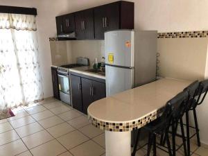a kitchen with a table and a refrigerator at Recidencial Pacifico in Rincon de Guayabitos