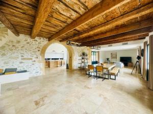 a large living room with a wooden ceiling and a table at Les Rives du Parc Piscine 12 personnes in Lédenon