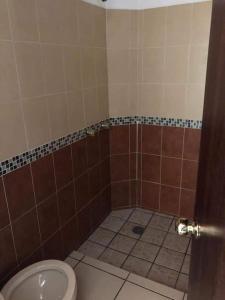 a bathroom with a toilet and a tiled floor at Recidencial Pacifico in Rincon de Guayabitos +26 photos