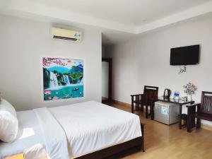 a bedroom with a bed and a flat screen tv at Phú Quốc Center Hotel in Phú Quốc