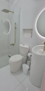 a white bathroom with a toilet and a shower at 2 BDR - Mangel Residence Aruba - NEW in Savaneta