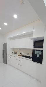 a white kitchen with white cabinets and a refrigerator at 2 BDR - Mangel Residence Aruba - NEW in Savaneta +33 photos
