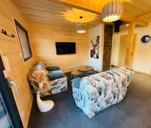a living room with two couches and a tv at Chalet Abies Alba in Gérardmer