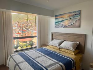 a bedroom with a bed and a large window at Mantu Apartment in Cusco