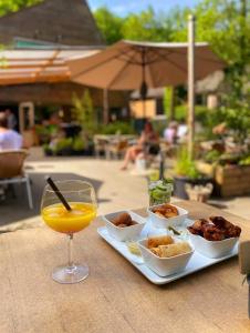 ein Tablett mit Essen und ein Glas Orangensaft in der Unterkunft Chalet Het Hulstje 1 in Durbuy