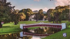 a bridge over a river with a house in the background at Apto Clássico, Centro de Friburgo, em frente à Pça Getúlio Vargas e pertinho do Teleférico e da Pça Suspiro - Muito bem equipado - Aquecedor in Nova Friburgo