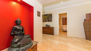 a statue of a woman sitting on a table in a room at Larasati - Palm Cove in Palm Cove