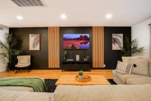 uma sala de estar com um sofá e uma televisão em Lazy Palms em Tempe