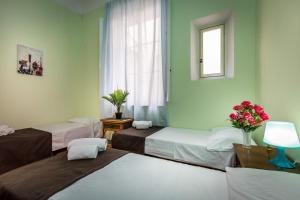 フィレンツェにあるRooms77 Florence centro storico firenzeのベッド3台と窓が備わる客室です。