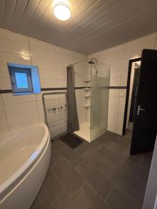 a bathroom with a tub and a shower and a toilet at Gîte Raynal in Les Junies +13 photos