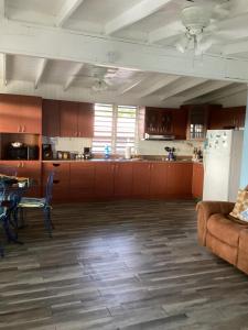 a kitchen with a couch and a table and a refrigerator at Sea Breeze Paradise in Cabo Rojo